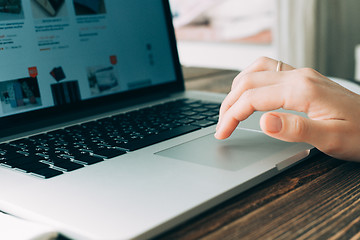 Image showing Woman working with laptop placed on wooden desk