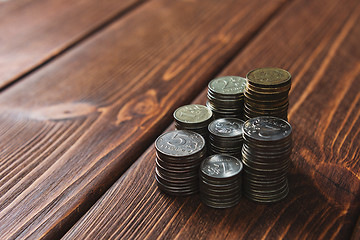 Image showing Top view coins on old wooden desk with copy space on top.