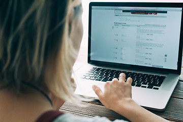 Image showing Woman working with laptop placed on wooden desk