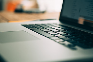 Image showing Workplace with open laptop on modern wooden desk 