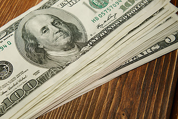 Image showing Bundle of money on wooden background