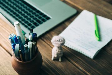 Image showing Workplace with open laptop on modern wooden desk 