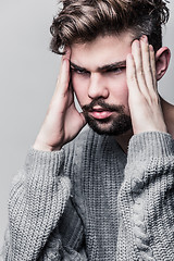 Image showing Portrait of a young man in gray pullover. Headache