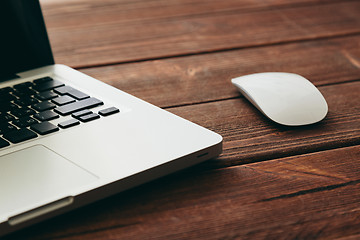 Image showing Close-up shot of laptop on old wooden desk