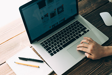 Image showing Woman working with laptop placed on wooden desk