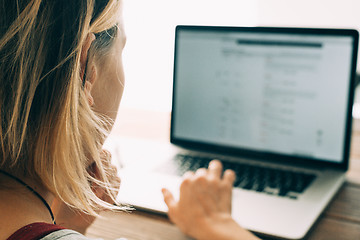 Image showing Woman working with laptop placed on wooden desk