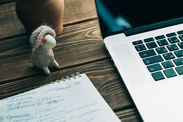 Image showing Workplace with open laptop on modern wooden desk 