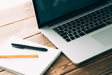 Image showing Workplace with open laptop on modern wooden desk 