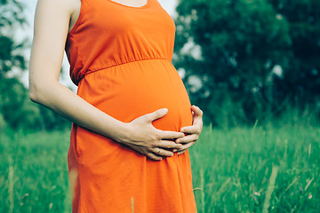 Image showing Pregnant woman, holding in hands bouquet of daisy 