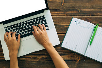 Image showing Woman working with laptop placed on wooden desk