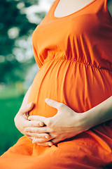 Image showing Pregnant woman, holding in hands bouquet of daisy 