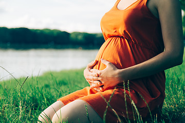 Image showing Pregnant woman, holding in hands bouquet of daisy 