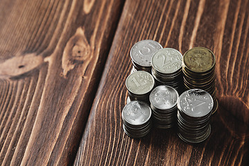 Image showing Top view coins on old wooden desk with copy space on top.