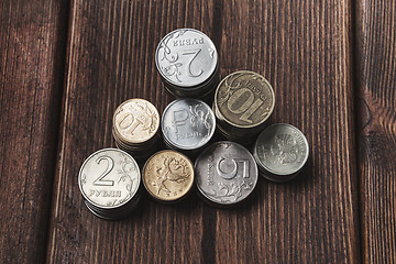 Image showing Top view coins on old wooden desk with copy space on top.