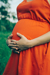 Image showing Pregnant woman, holding in hands bouquet of daisy 