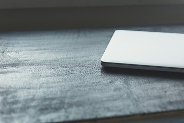 Image showing Closed aptop on modern wooden desk 