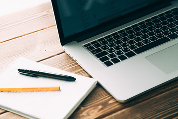 Image showing Workplace with open laptop on modern wooden desk 