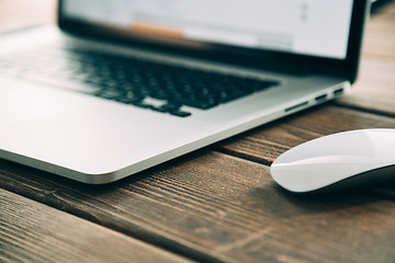 Image showing Workplace with open laptop on modern wooden desk 