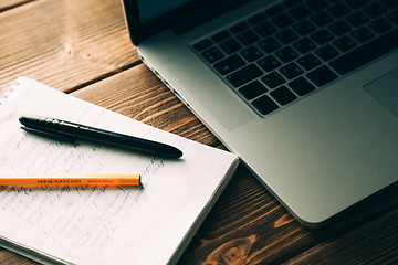 Image showing Workplace with open laptop on modern wooden desk 