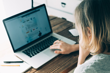 Image showing Woman working with laptop placed on wooden desk