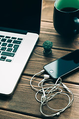 Image showing Workplace with open laptop on modern wooden desk 