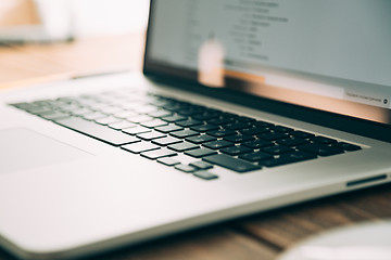 Image showing Workplace with open laptop on modern wooden desk 