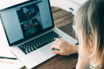 Image showing Woman working with laptop placed on wooden desk