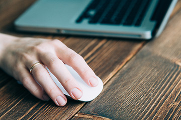 Image showing Woman working with laptop placed on wooden desk