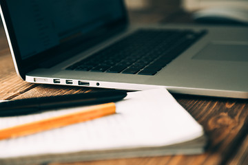 Image showing Workplace with open laptop on modern wooden desk 