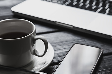 Image showing Office table with notepad, computer and tea cup