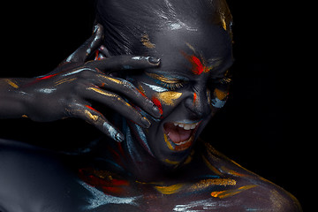 Image showing Portrait of a young woman who is posing covered with  black paint 