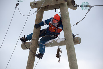 Image showing electrician working on top of an electricity pylon