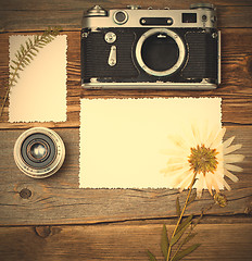 Image showing mockup stillife with retro photo, camera, lens and pressed plant