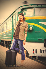 Image showing beautiful middle-aged woman with luggage on a railway platform n