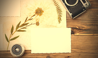 Image showing still life with copy space photo, lens, retro camera and pressed