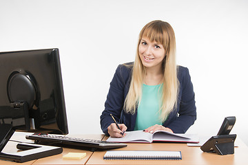Image showing Business woman wrote in a notebook and looked into the frame