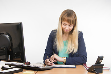 Image showing Business woman looking at his watch and schedule of the working day