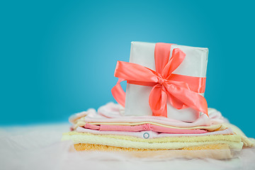 Image showing The baby clothes with a  white gift box