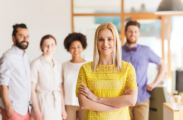 Image showing happy young woman over creative team in office