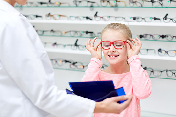 Image showing optician and girl choosing glasses at optics store