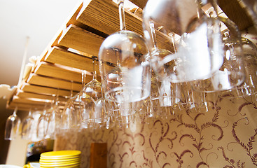 Image showing wine glasses hanging upside down on bar holder