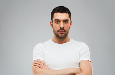 Image showing young man with crossed arms over gray background