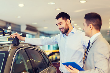 Image showing happy man with car dealer in auto show or salon
