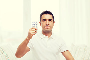 Image showing man showing pack of pills at home