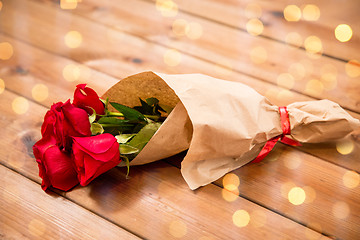 Image showing close up of red roses bunch wrapped into paper