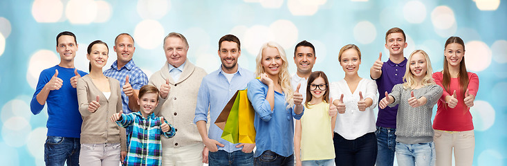 Image showing happy people with shopping bags showing thumbs up