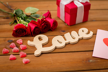 Image showing close up of gift box, red roses and greeting card