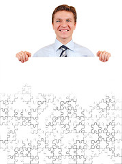 Image showing Confident business man holding a white puzzle board for copy-spa