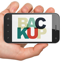 Image showing Software concept: Hand Holding Smartphone with Backup on  display