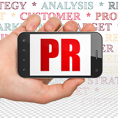 Image showing Advertising concept: Hand Holding Smartphone with PR on display